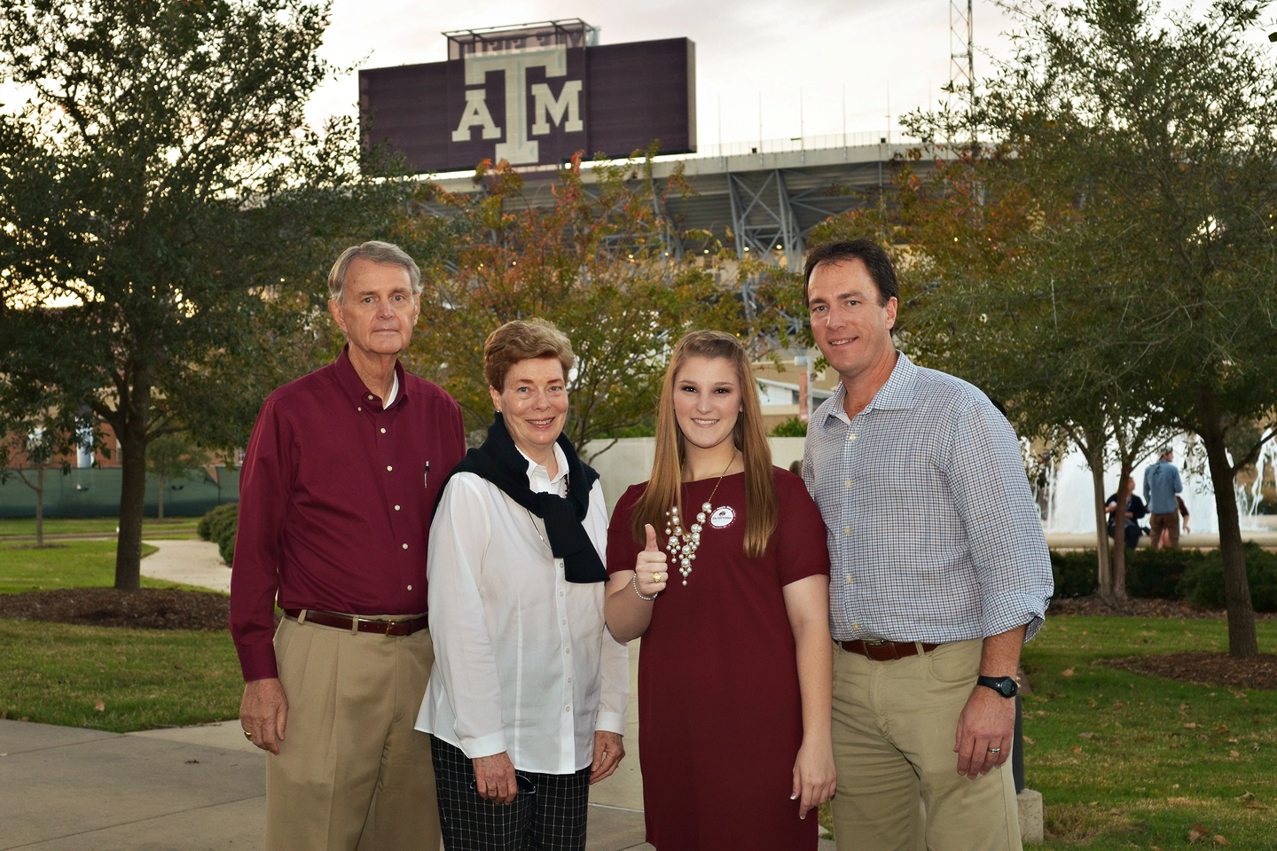 Chandler with his family standing behind the Texas A&M Stadium bleachers